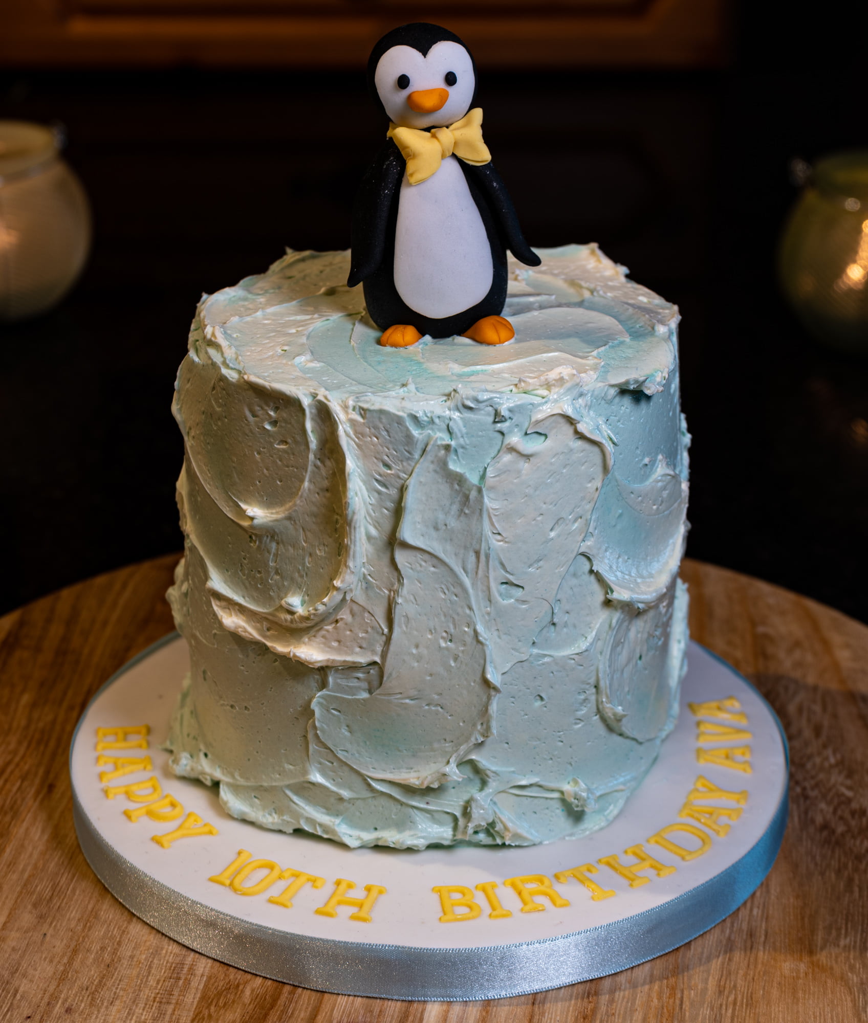 Cute penguin on ice blue birthday cake