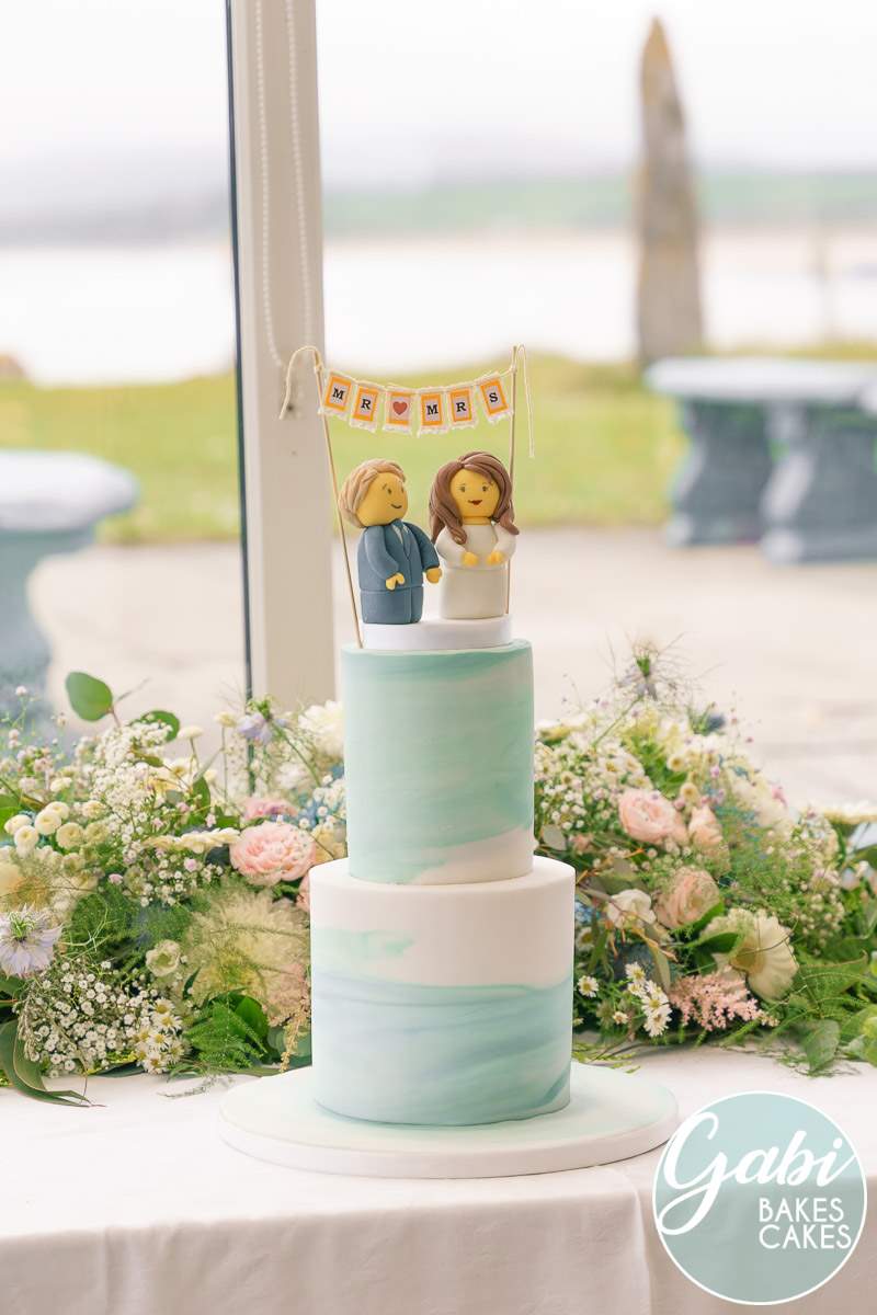 Cute blue and white wedding cake with couple topper.
